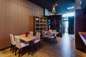 Gemütlicher Sitzbereich mit Holztischen und moderner Wandtäfelung.